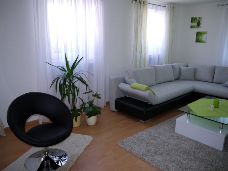 Wohnzimmer mit Drehsessel und Grünpflanze