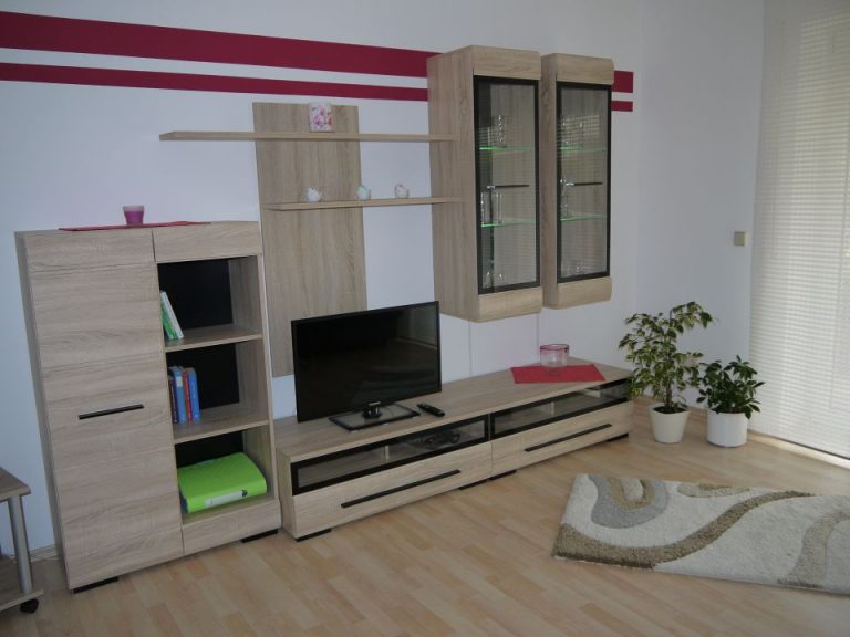 Wohnzimmer mit heller Wohnwand und TV