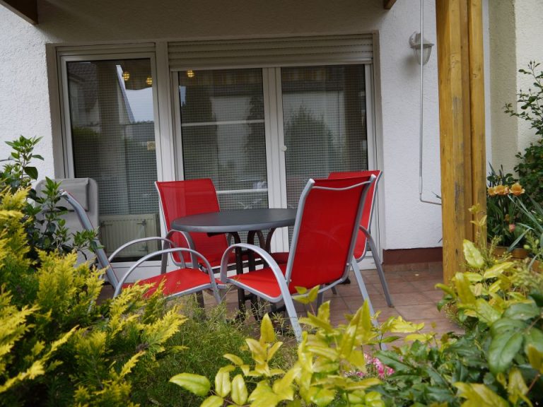 Terrasse mit roten Gartenstühlen