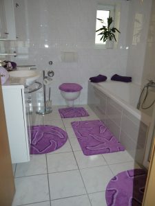 Lila eingerichtetes Badezimmer mit Dusche